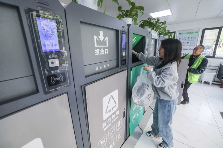 2024年4月10日，在浙江省湖州市吳興區(qū)飛英街道新華府小區(qū)內(nèi)，居民在垃圾分類智能系統(tǒng)的指導下進行垃圾分類投放，居民的投放情況將實時匯總到智慧服務平臺，會有相應的積分獎勵。新華社記者 徐昱 攝