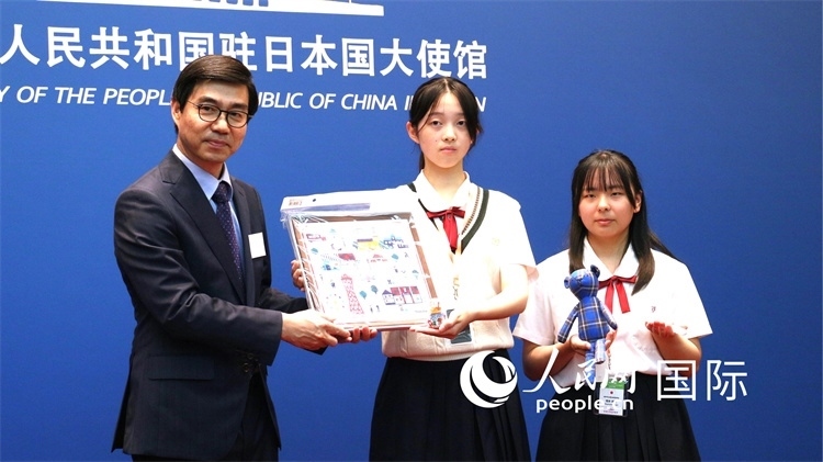 日本小大使向中國(guó)駐日本大使館臨時(shí)代辦施泳贈(zèng)送當(dāng)?shù)靥厣Y品。人民網(wǎng) 許可攝