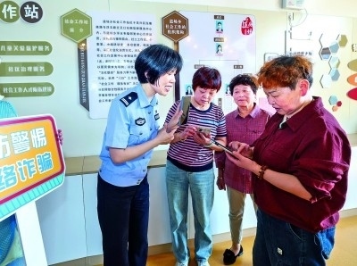 浙江湖州民警指導(dǎo)居民加入湖州“e企安”微信群，實(shí)時(shí)接收反詐信息。新華社發(fā)