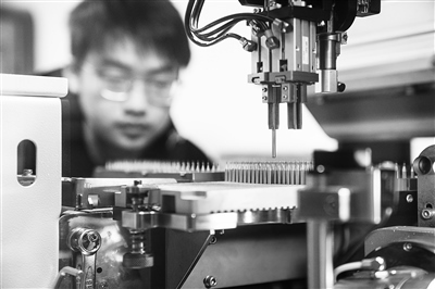 四川某公司，工人正進行微型鉆頭研磨鉆尖工序操作。