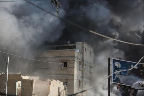 7月21日，在加沙地帶中部的努賽賴特難民營(yíng)，遭以軍空襲的建筑冒出滾滾濃煙。新華社發(fā)（馬爾萬(wàn)·達(dá)烏德攝）