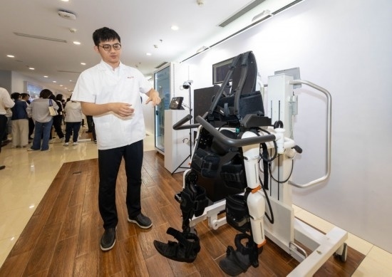 2024年5月24日，在位于上海市嘉定區(qū)的上海交通大學(xué)醫(yī)學(xué)院附屬瑞金醫(yī)院腫瘤質(zhì)子中心，工作人員介紹由瑞金醫(yī)院醫(yī)生和醫(yī)療公司共同研發(fā)的用于恢復(fù)患者下肢的醫(yī)療機(jī)器人。新華社記者 王翔 攝