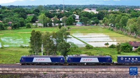 8月5日，由老撾籍火車司機(jī)獨(dú)立駕駛的滿載貨物的列車駛出萬象站，向中國昆明進(jìn)發(fā)（無人機(jī)照片）。新華社發(fā)（楊永全 攝）