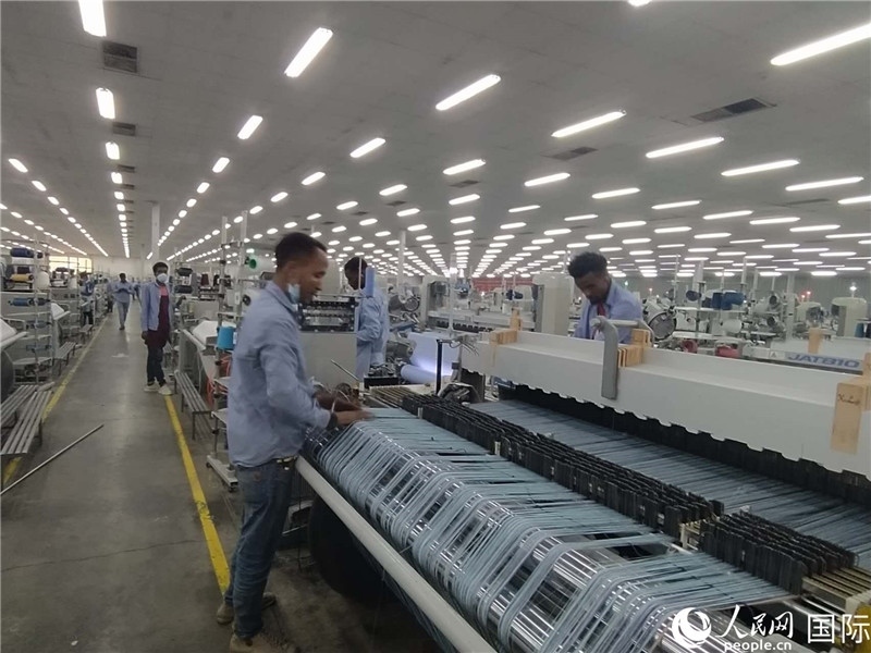 無錫金茂埃塞面料廠車間內(nèi)，當(dāng)?shù)毓と苏谝唤z不茍地作業(yè)。人民網(wǎng)記者 黃培昭攝