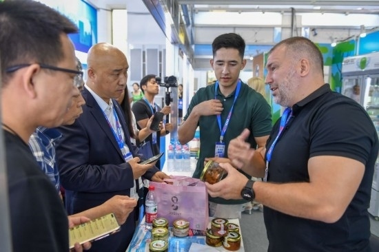 2023年8月23日，在第十四屆中國(guó)—東北亞博覽會(huì)東北亞商品館，俄羅斯參展商向參觀者介紹商品。