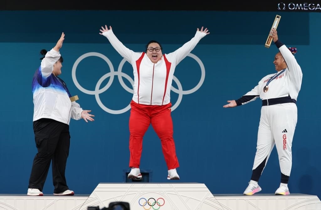 中國選手李雯雯（中）在巴黎奧運(yùn)會舉重女子81公斤以上級頒獎儀式中登上領(lǐng)獎臺（2024年8月11日攝）。新華社記者 楊磊 攝