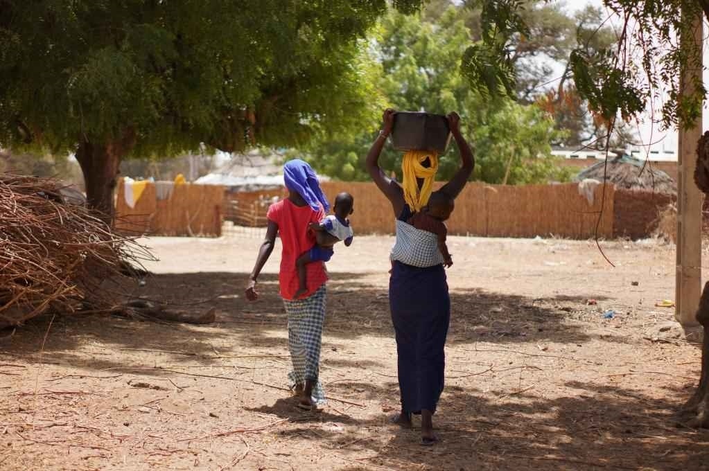 2023年3月20日，在塞內(nèi)加爾久爾貝勒區(qū)的泰內(nèi)富勒村，村民將取到的水運回家。新華社記者 王子正 攝