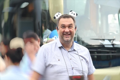 參訪熊貓谷前，塞爾維亞“一帶一路”研究所所長博揚·拉利奇戴上熊貓頭飾。（李佩藺 攝）