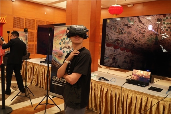1、在本次活動的展覽現(xiàn)場，敦煌研究院與騰訊展示了“數(shù)字藏經(jīng)洞”和“尋境敦煌”等創(chuàng)新互動產(chǎn)品。圖為當(dāng)?shù)孛癖娡ㄟ^VR虛擬游覽洞窟。 人民網(wǎng)記者 李志偉攝