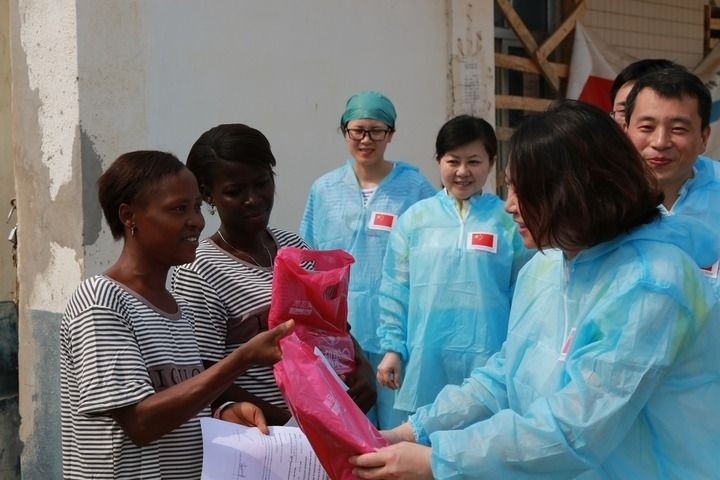 2015年4月4日，在位于塞拉利昂首都弗里敦市郊的中塞友好醫(yī)院埃博拉診療中心，中國第四批援塞醫(yī)療隊(duì)副隊(duì)長邵蔚（右前）向被治愈的埃博拉出血熱患者贈(zèng)送禮物。新華社發(fā)（祖榮強(qiáng) 攝）
