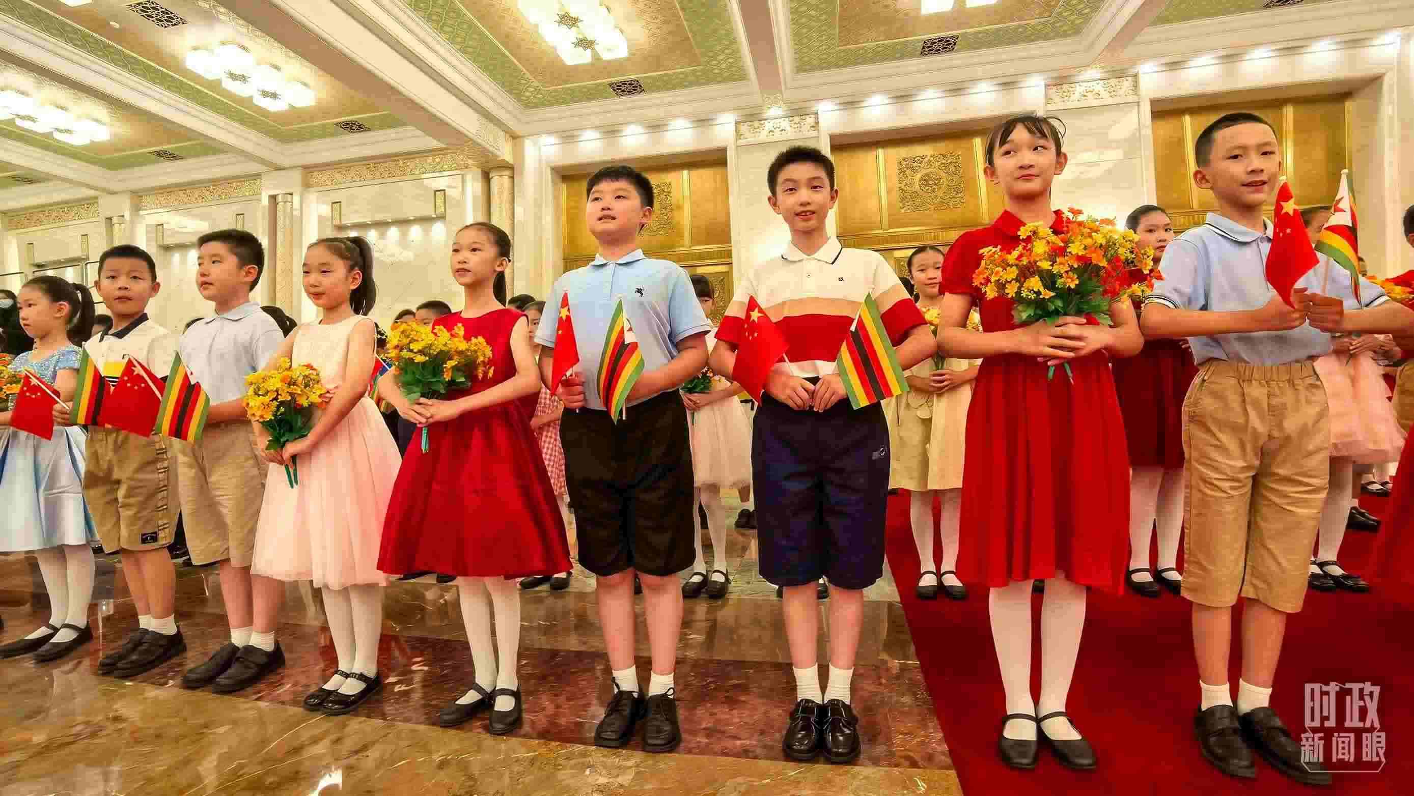 △現(xiàn)場歡迎津巴布韋總統(tǒng)訪華的青少年。（總臺央視記者鐘銳拍攝）