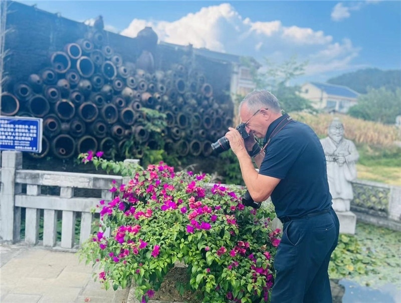 遠(yuǎn)處黔北民居錯(cuò)落有致，近處一只黑色的蝴蝶穿梭于粉紫色三角梅花叢間隙，與俄羅斯“大歐亞”總編輯弗拉基米爾·別列日內(nèi)赫的鏡頭玩起了捉迷藏，“你追我逃，不亦樂乎”。（張亞欣攝）