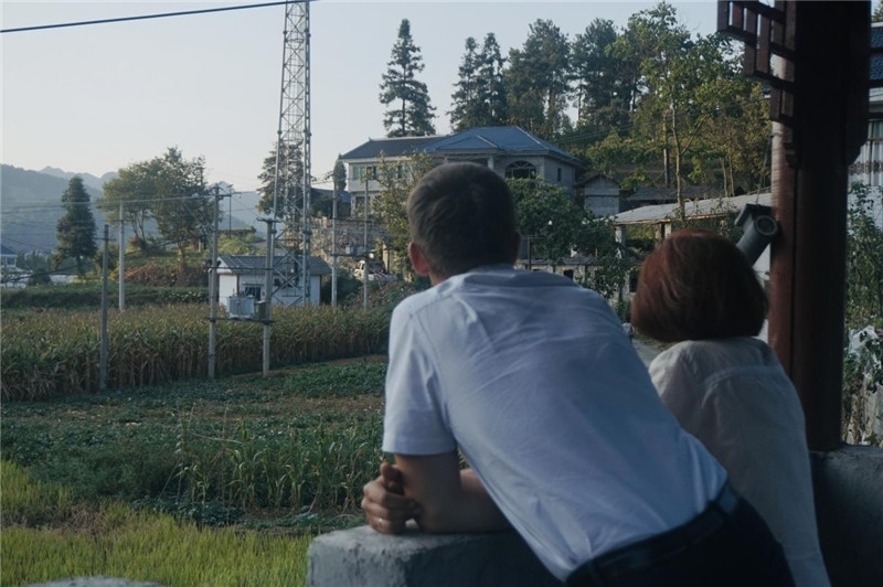 望得見山，看得見水，記得住鄉(xiāng)愁。每個(gè)人心中都有一個(gè)屬于自己的“花茂村”，在這方心田，走遍千山萬水，鄉(xiāng)音未改鬢毛衰。吉爾吉斯斯坦《比什凱克晚報(bào)》第一副總編輯妮娜·尼奇博洛娃與《中國(guó)與俄羅斯》雜志社社長(zhǎng)奧列格·別列日內(nèi)赫攝在花茂村民居屋檐下并肩佇立，眺望山水，尋覓鄉(xiāng)愁。（李光裕攝）