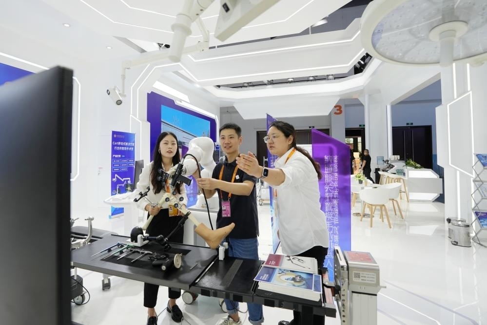 9月11日，一位媒體記者（中）在2024年服貿(mào)會(huì)國(guó)家會(huì)議中心會(huì)場(chǎng)體驗(yàn)北京納通科技集團(tuán)有限公司的膝關(guān)節(jié)置換手術(shù)機(jī)器人。新華社記者鞠煥宗 攝