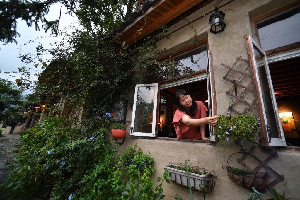 8月29日，在福建省屏南縣熙嶺鄉(xiāng)，龍?zhí)洞濉靶麓迕瘛泵泛暝诖蚶碜约航?jīng)營的民宿外墻裝飾花盆。新華社記者姜克紅 攝