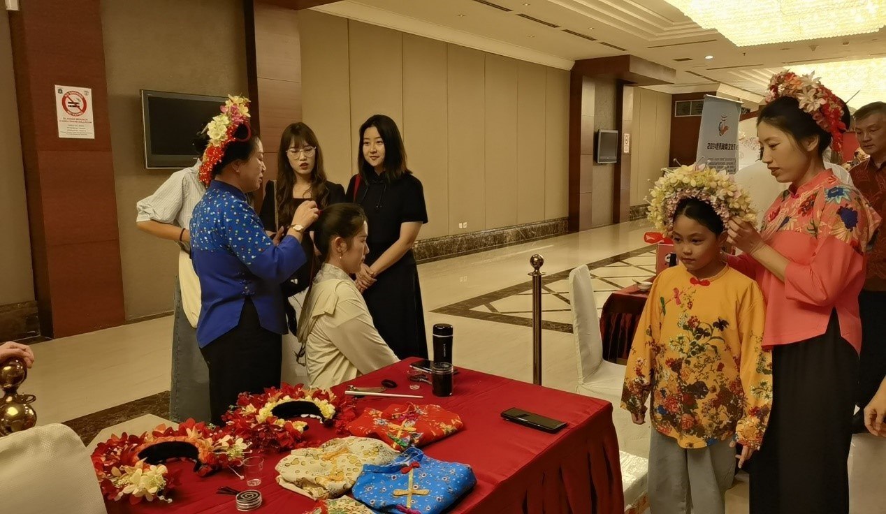 阿拉扎大學孔子學院志愿者老師向傳承人學習簪花圍。阿拉扎大學孔子學院供圖