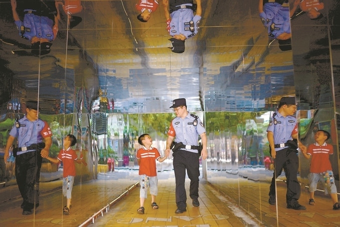 ?7月16日，重慶市公安局江北區(qū)分局一名民警在巡邏途中遇到一個獨(dú)自玩耍的小男孩，民警將其送回家。王洪平攝