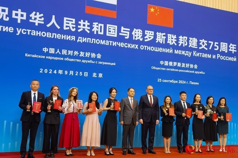 楊萬明會長和莫爾古洛夫大使為10位中俄青年友好微視頻創(chuàng)意大賽獲獎代表頒獎。人民網(wǎng)記者 李明琪攝