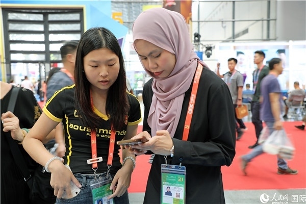 東博會(huì)現(xiàn)場，馬來西亞展商在同中方工作人員交談。人民網(wǎng)記者 趙益普攝