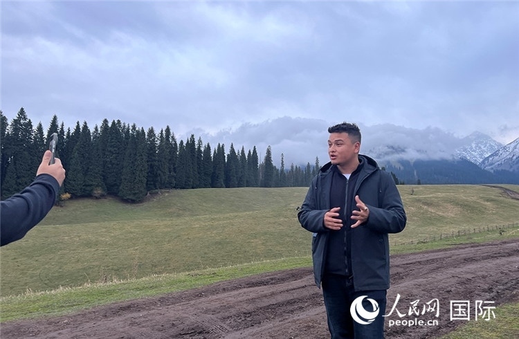 在庫爾德寧，吾買爾江被雪山美景震撼，即興錄制了短視頻作品。人民網(wǎng)記者曾書柔攝