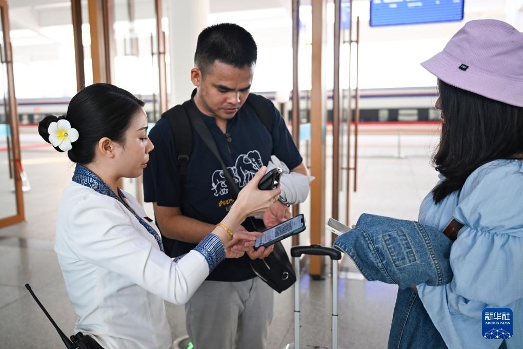 10月12日，在老撾萬(wàn)象中老鐵路萬(wàn)象站，工作人員檢驗(yàn)乘客車(chē)票。新華社記者 程一恒 攝
