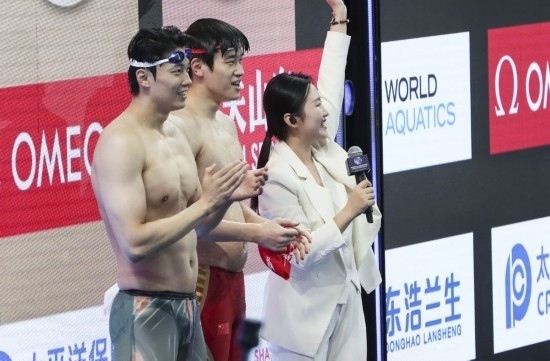  10月18日，汪順（左）和潘展樂在男子100米混合泳決賽后。新華社記者 方喆 攝