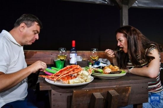 9月2日，食客們?cè)诙砹_斯符拉迪沃斯托克的一家餐館品嘗帝王蟹。新華社記者 曹陽 攝