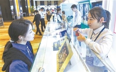 在北京麗澤商務(wù)區(qū)，工作人員（右一）介紹數(shù)字人民幣SIM卡硬錢包。新京報記者 陶冉攝