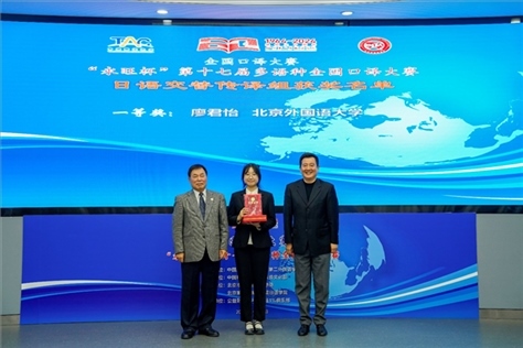 中國翻譯協(xié)會副會長中國外文局中東歐與中南亞傳播中心（人民畫報社）主任姜永鋼（右一）、原中國教育工會全國委員會巡視員白立文（左一）為獲得日語交傳組一等獎的北京外國語大學廖君怡頒獎（主辦方提供）