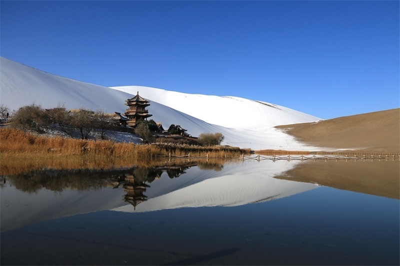 鳴沙山月牙泉景區(qū)雪景。敦煌市委宣傳部供圖，張曉亮攝