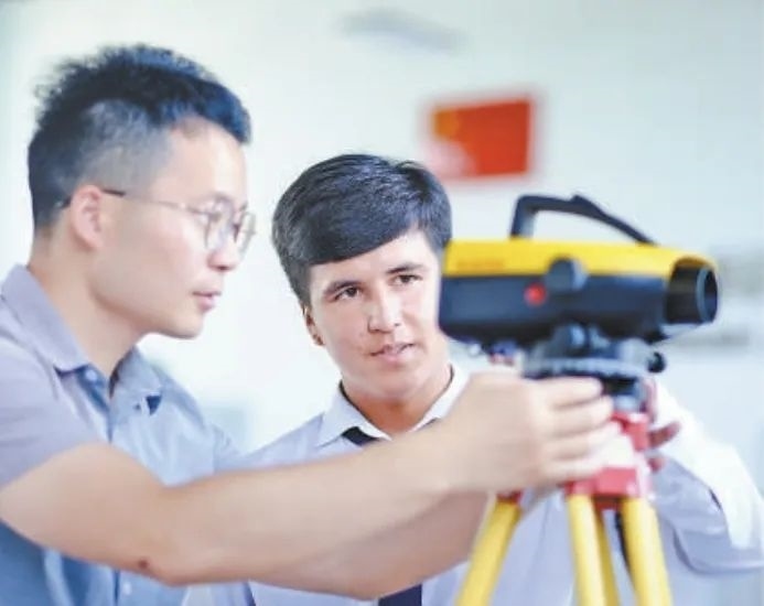 在塔吉克斯坦首都杜尚別的魯班工坊，來自天津城市建設(shè)管理職業(yè)技術(shù)學院的老師（左）為當?shù)貙W生提供指導。新華社記者 鄭開君 攝