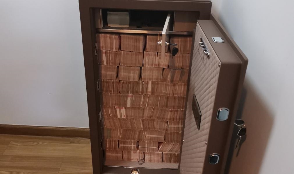 圖為警方查獲藏匿于保險柜中的現(xiàn)金。（警方供圖）