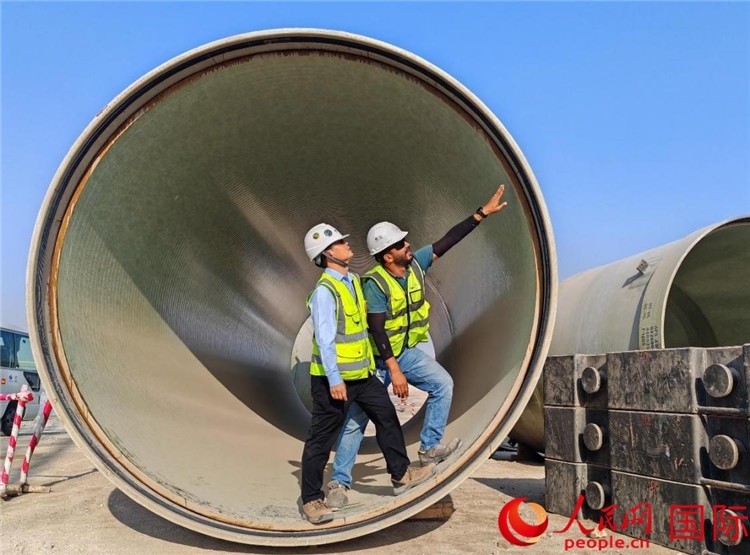 工作人員在察看輸水管情況。人民網(wǎng)記者 管克江攝