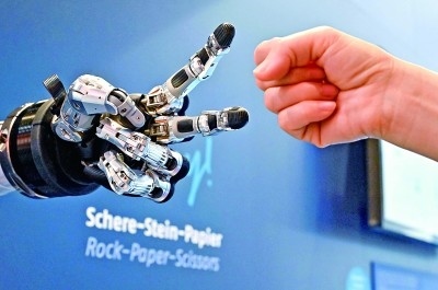 在德國(guó)漢諾威工博會(huì)上，參觀者與一款智能機(jī)器人進(jìn)行“石頭剪子布”游戲。新華社發(fā)
