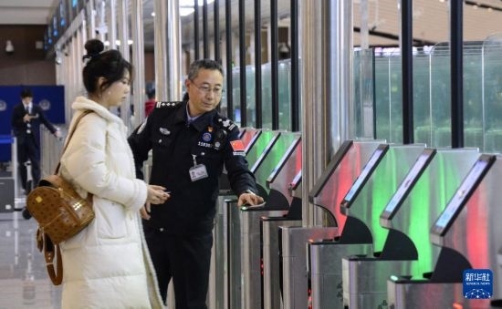 1月2日，大興機(jī)場邊檢站警察指導(dǎo)旅客使用自助出境設(shè)備。新華社記者 李欣 攝