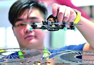 在首屆晉江科技成果轉(zhuǎn)化對接洽談會(huì)智能裝備展位，工作人員在展示無人機(jī)研究成果。新華社發(fā)