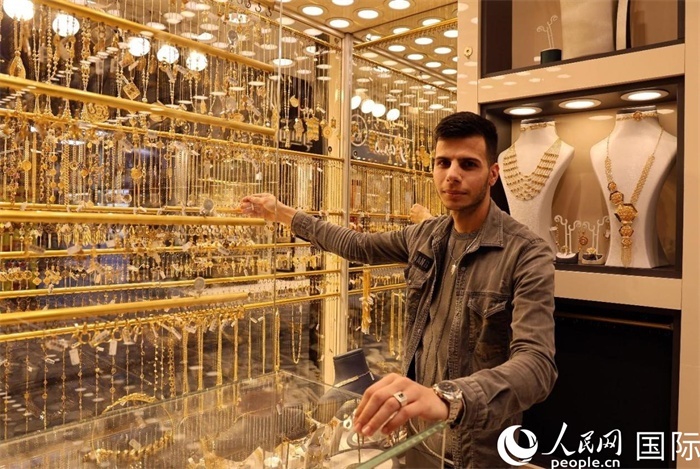 一名銷售員展示黃金飾品。人民網(wǎng) 伊納斯·易卜拉欣攝