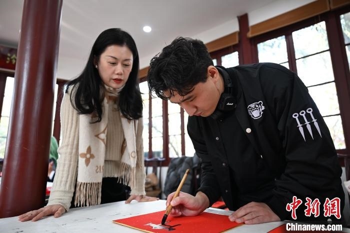 1月20日，外籍留學生在西泠印社社員李硯指導下寫福。當日，來自巴西、馬來西亞、加納、哈薩克斯坦的外籍留學生在浙江杭州西泠印社體驗福貼、春聯(lián)和篆刻，感受古老的中國傳統(tǒng)文化。中新社記者 王剛 攝