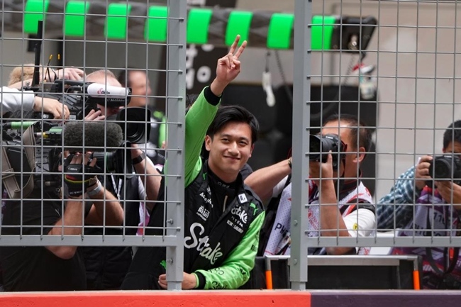 2024年4月19日，索伯車隊(duì)中國(guó)車手周冠宇（中）在練習(xí)賽前向觀眾致意。當(dāng)日，F(xiàn)1中國(guó)大獎(jiǎng)賽在上海開(kāi)賽。中國(guó)車手周冠宇主場(chǎng)首秀參賽。新華社記者 夏一方攝