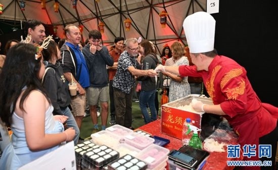 圖為游客在燈節(jié)現(xiàn)場購買小吃。（圖片由奧克蘭中國文化中心提供）