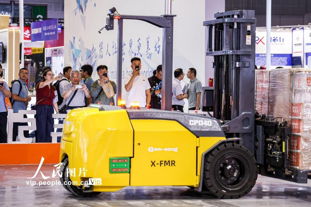 第24屆中國工博會(huì)現(xiàn)場，觀眾觀看叉取機(jī)器人作業(yè)演示。王初攝（人民圖片網(wǎng)）