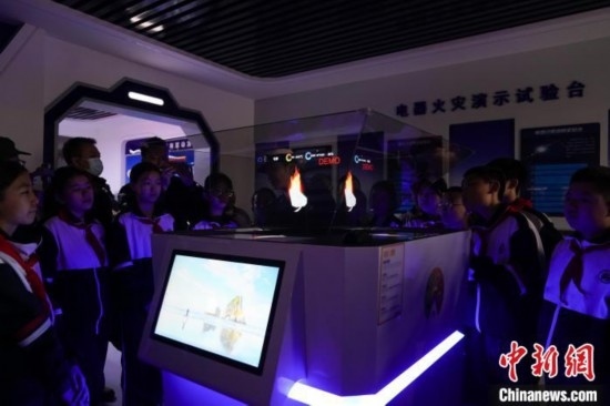 圖為學(xué)生們參觀道里區(qū)消防救援大隊消防科普體驗館內(nèi)幻影成像燃燒三要素實驗臺。中新社記者 趙宇航 攝