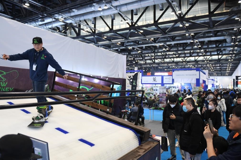 2023年2月11日，參觀者在展會上了解一款模擬滑雪設(shè)備。當(dāng)日，2023亞洲運(yùn)動(dòng)用品與時(shí)尚展在國家會議中心拉開帷幕。新華社記者 張晨霖 攝