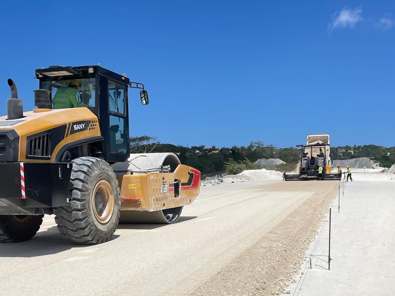 圖為中企承建的牙買加蒙特哥貝繞城路項目基層試驗段正在進行攤鋪和碾壓施工，相關施工工作已于日前順利完成。中國港灣美洲區(qū)域公司供圖