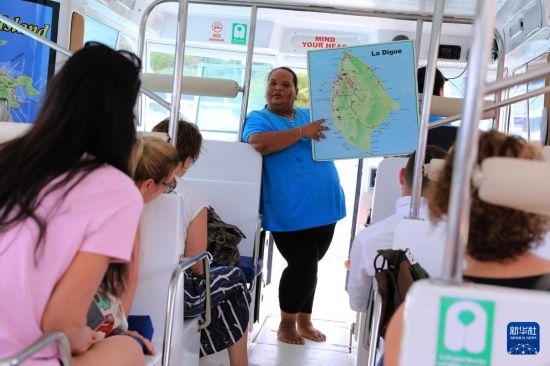 3月15日，一名導(dǎo)游在游艇上為游客介紹塞舌爾拉迪格島。新華社記者 董江輝 攝