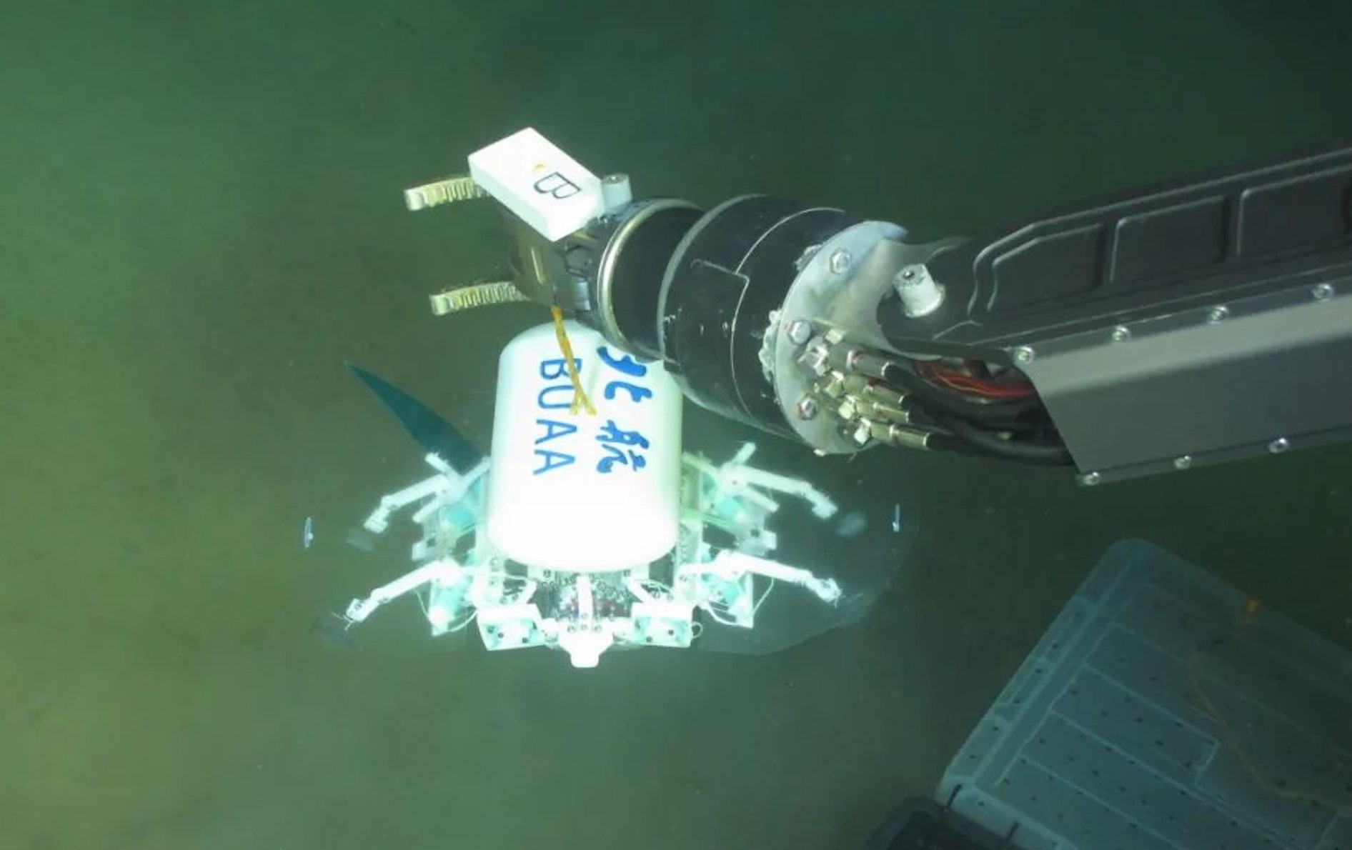 科研人員利用機(jī)械臂將北航深海小型機(jī)器人投于馬里亞納海溝。校方供圖