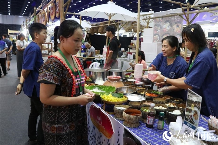 游客在攤位前購(gòu)買(mǎi)特色美食。朱瀟逸攝