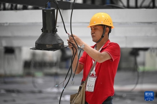 4月4日，工作人員在海南國(guó)際會(huì)展中心內(nèi)布設(shè)燈光。