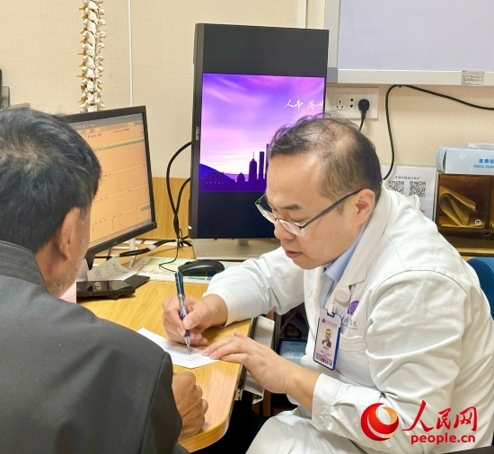 路桂軍接診時為患者寫下用藥提示。人民網(wǎng)記者 金慧慧攝