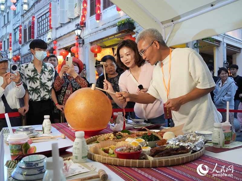 嘉賓品嘗海南傳統(tǒng)美食“煎堆”。人民網(wǎng)記者 張力洋攝